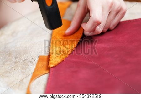 A Leather Craftsman Produces Leather Goods. He Taps The Hammer.