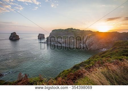 Two Sisters At The Orange Sunrise In Hendaye From The Top Of Mount On The Beach, France