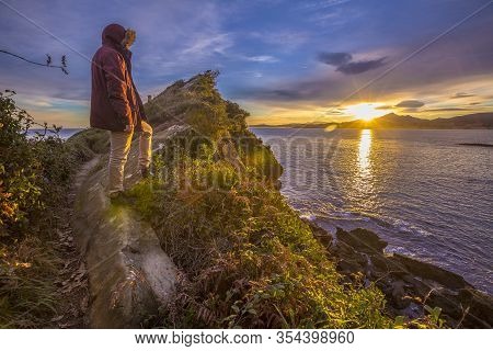 A Young Man Watching The Dawn Of The Town Of Fuenterrabia. Basque Country