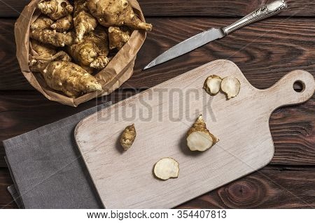 Several Jerusalem Artichoke Tubers In A Paper Bag On A Wooden Table With Copy Space. Helianthus Tube