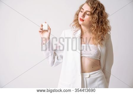Attractive Curly Blonde Girl With Red Lips Dressed In White Suit And Lace Bra Holds In Her Hands Wir