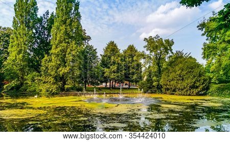 The Pond With Water Fountains In The City Park Valkenberg Of Breda, Nature Scenery Of The Netherland