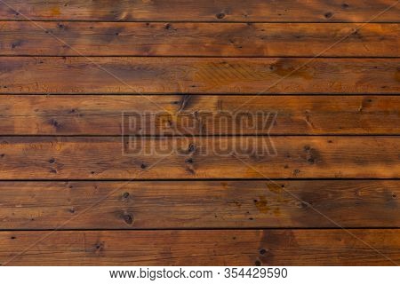 Stained wet deck wooden boards with water drops, brown planks texture