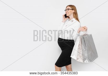 Image Of Young Pregnant Businesswoman Wearing Glasses, Talking On Phone, Holding Bags, Shopping