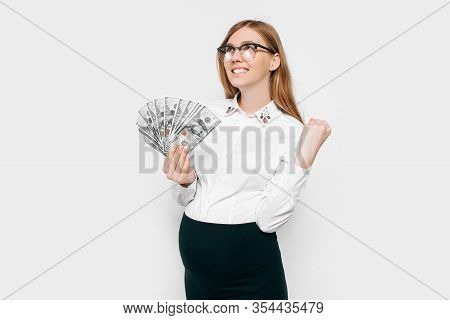 Image Of A Young Pregnant Businesswoman In Glasses Posing, Holding Banknotes In Her Hands Depicting