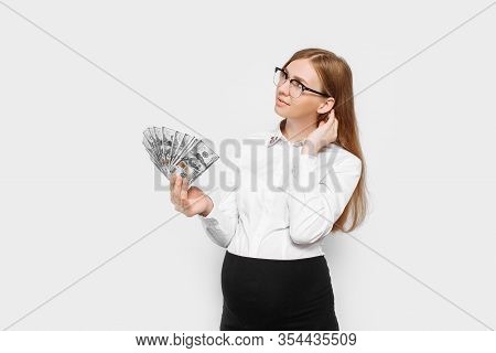 Image Of A Young Pregnant Businesswoman In Glasses Posing, Holding Banknotes In Her Hands, Planning