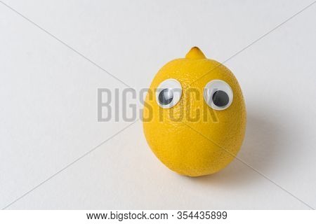 Fresh Lemon With Eyes On White Background. Food With Funny Face
