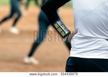 Third Base Coach For Fast Pitch Softball Team Wears Strategic Offensive Play Arm Band With Disguised