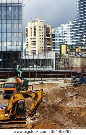 Consruction Site With Excavator And Modern Buildings On Background