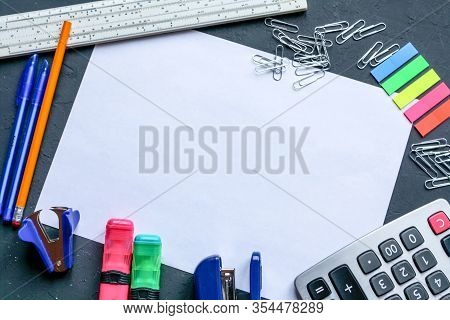 Stationery Is Placed Around A White A4 Sheet Of Paper. Markers, Pencils, Pens, Calculator, Bookmarks