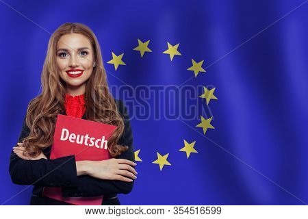 Happy Woman Student With Deutsch Book Against The European Union Flag Background. Book With Inscript