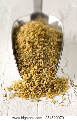 Heap Of Uncooked, Raw Freekeh Or Firik, Roasted Wheat Grain, In Metal Scoop On White Rustic Table Ba