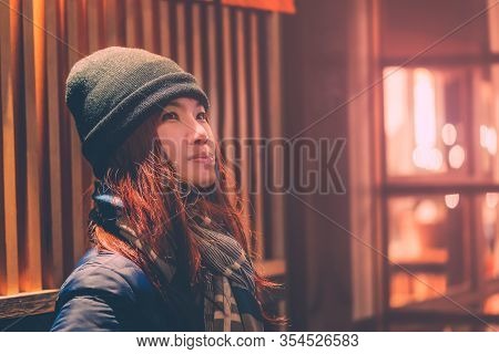 Portrait Of Female Tourist Traveling In Ginzan Onsen With Snow Falling At Night