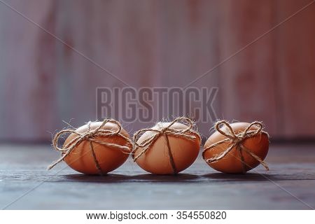 Easter Beige Eggs Decorate With Rope On Brown Wooden Background