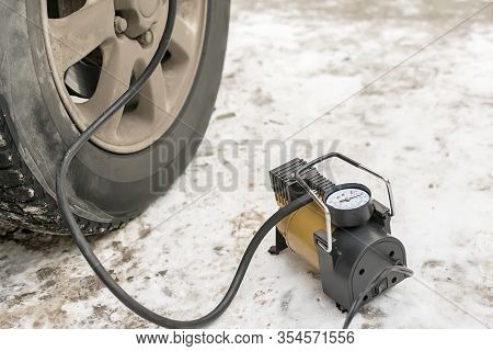 Pump, Automobile Compressor For Inflating Tires With Air Stands In The Winter On The Snow And Pumps 