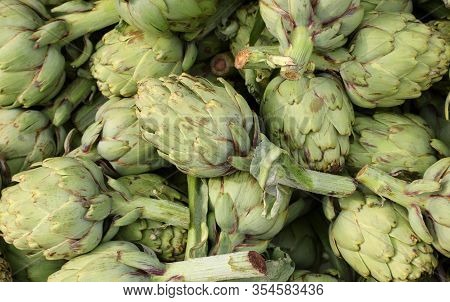 Background Of Fresh Artichokes For Sale In The Greengrocer Stall At The Local Market