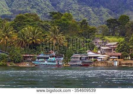 Parapat, Indonesia - January 1, 2020. Berth For Pleasure Boats And Ferries On Lake Toba Against A Ba