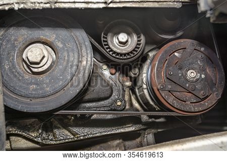 Crankshaft Pulley Connected By A Multi-ribbed Belt With Tensioner And Air Conditioning Compressor.