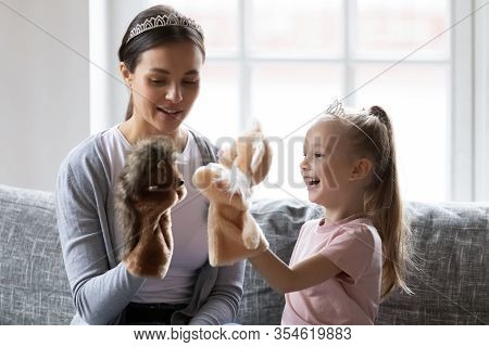 Happy Little Girl Wearing Crown Playing Hand Toys With Babysitter.
