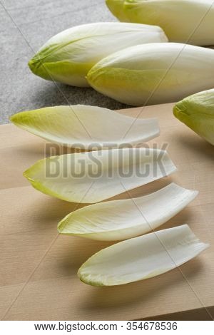 Fresh raw Belgian endive leaves close up on a cutting board