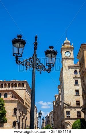 Beautiful Street Lamp And The Clock Tower Of An Antique Building At Zamora Street In Salamanca City
