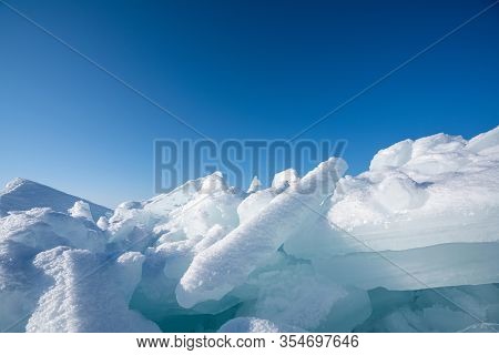 Closeup Ice That Covered With White Snow. Water In The Lake Became Frozen During Winter Period. Lake