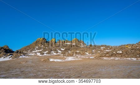 The Rocky Mountains Are Covered With Snow. The Blue Color Of The Sky Contrasts With The Brown Color 