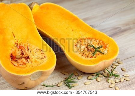 Pumpkin Butternut Liscia Cut In Half.   Yellow Delicious Pumpkin On Wooden Table.