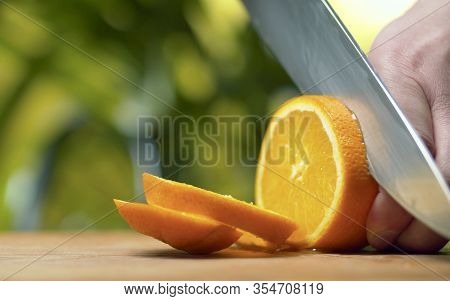 Male Hand Slicing An Orange