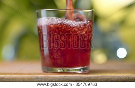 Red Juice Pouring Into The Glass