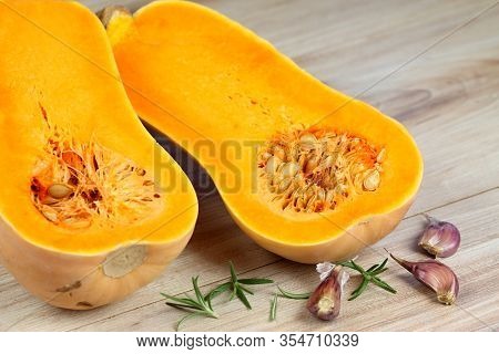 Pumpkin Butternut Liscia Cut In Half.   Yellow Delicious Pumpkin On Wooden Table.