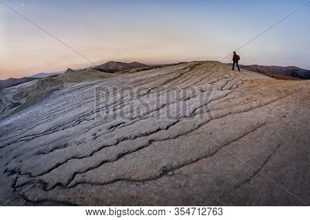 Young Man Walking In A Lunar Landscape Over The Muddy Volcanoes, Paclele, Berca, Buzau County, Roman