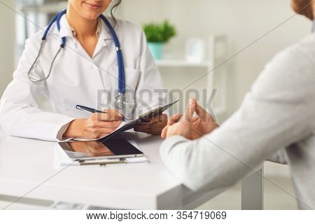 Female Doctor Therapist Gross Allergist Nutritionist Otolaryngologist And Male Patient Sitting At A 