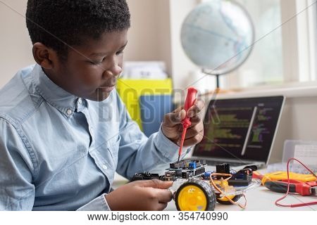 Male High School Pupil Building Robot Car In Science Lesson