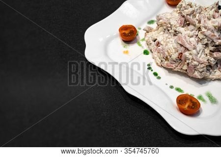 A Fragment Of A White Plate With Salad, Tomatoes And Green Sauce On A Black Background. Freespace.
