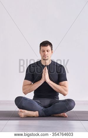 Man Yoga Class. Black Wear. Calm Relax Pose. Closed Eyes. Zen Exercise. Male Person Sitting At Mat. 