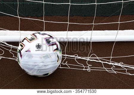 Soccer Ball With Medical Mask On Field. Euro 2020 Football Tournament. Close Up