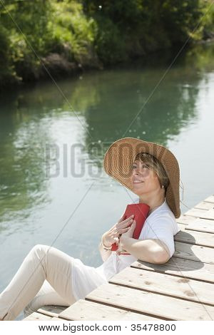 Frau sehr beim Lesen eines Buches von Fluss