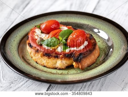 Italian Bruschetta With Mozzarella, Riccotta, Baked Tomatoes And Basil