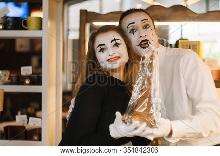 Happy Man Mime Giving A Chocolate Eiffel Tower To His Girlfriend. Two Happy Mimes On A Date In The C