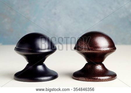 Two Metal Door Handles Covered With Shagreen, Brown And Black Paint Stand On The Table, Close -up. D