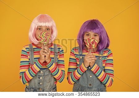 Sugary Food To Keep For Yourselves. Small Children Hold Lollipops Yellow Background. Little Girls En