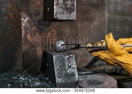Power Hammer Turns Into A Sphere A Metal Workpiece Held By A Blacksmith With Pincers