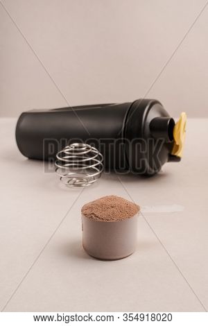 Whey Protein Powder In Scoop And Plastic Shaker On Neutral Beige Background. Vanilla And Chocolade F