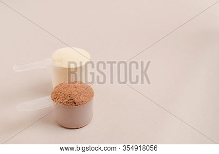 Whey Protein Powder In Scoop And Plastic Shaker On Neutral Beige Background