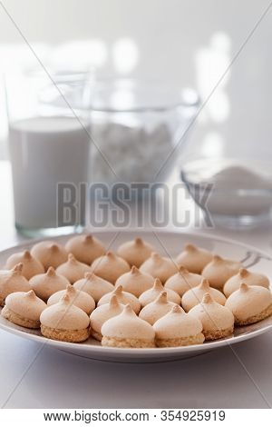 Merinque Cookies In White Plate. Glass Of Milk, White Bowls Background.high Key Food Photography.