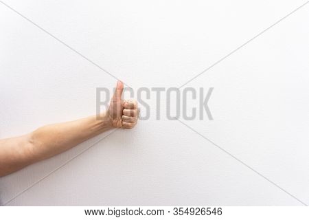 Left Hand Of White Caucasian Woman Or Girl Makes Thumb Up Gesture, Approves Or Agrees, White Backgro