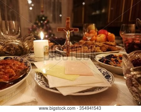 Lithuanian Christmas Eve table with Christmas wafers, candle and various dishes