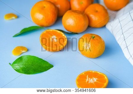 Top View Of Ripe Fresh Mandarines Or Tangerina Orangers With Green Leaves In Blue Background With Pl