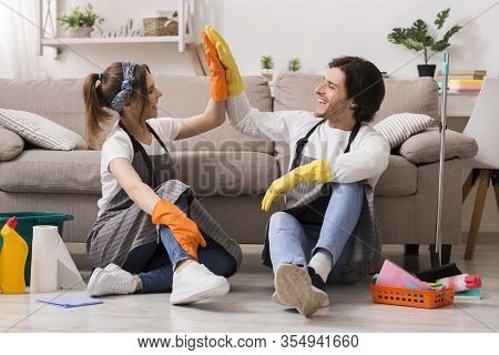 Housekeeping And Cleaning Service Concept. Happy Couple Giving High Five To Each Other After Spring-